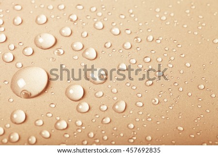Drops of water on a color background. Beige. Shallow depth of field. Selective focus. Toned.