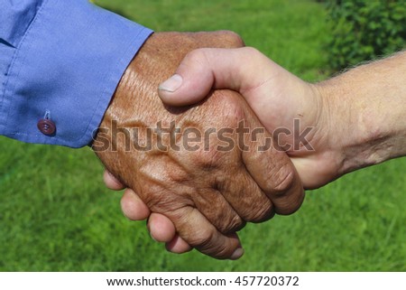 Handshake of business partners, farmers on green background