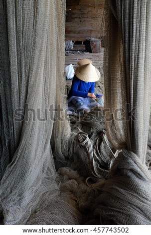 Vietnamese woman sewing fishing net at Ca Mau,Vietnam