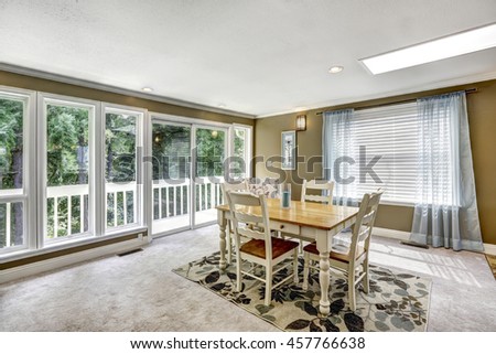 Nice dining room interior with soft blue curtain and floral carpet. White and brown carved table set. Northwest, USA.