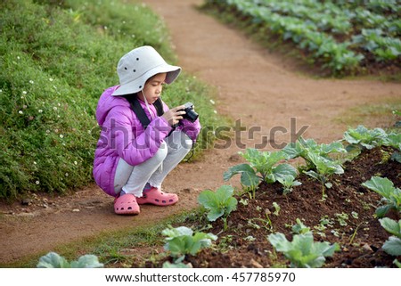 young Asian girl taking photograph of vegetable  in Maerim, Maecham, Chiangmai, north of Thailand