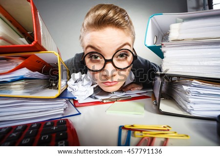 Workaholism mental insanity weird job work company concept. Insane office woman at work. Mad secretary making silly expression lurking through her desk. Royalty-Free Stock Photo #457791136