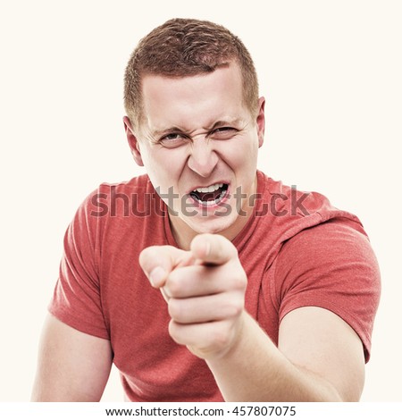 Young man on white background menacingly points a finger. Toned photo.