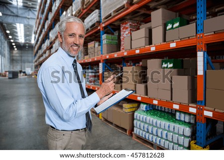 Worker holding clibpoard in a warehouse