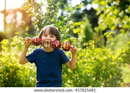 Cute little child, boy, holding a love sign, made from apples, letter graved in the apple, smiling happily. happiness childhood love concept