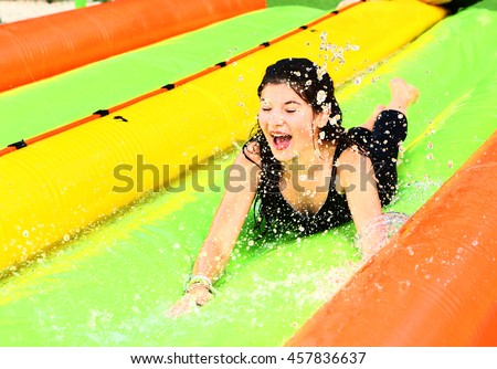 pretty teenager girl on the water slide in amusement aqua park close up photo
