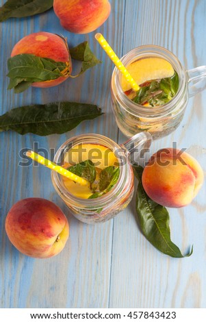 Homemade lemonade of ripe peaches and cold fresh mint. A jar of peach tea. Refreshing water. 