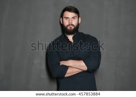 Portrait of handsome man with beard. Serious man in black shirt