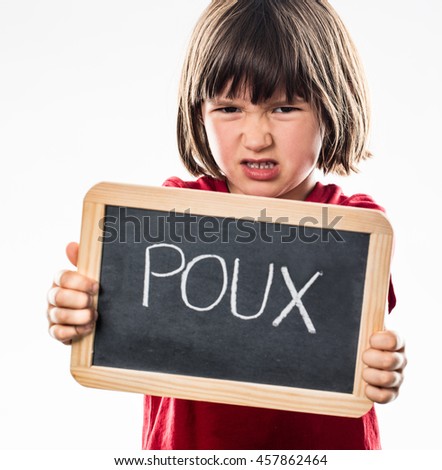 furious young boy showing a school slate as a shield in the foreground to repulse head lice, with 'poux' written in French, white background studio
