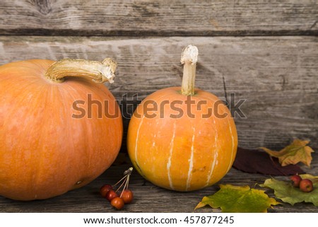 Pumpkins and fall leaves on an old wooden table 