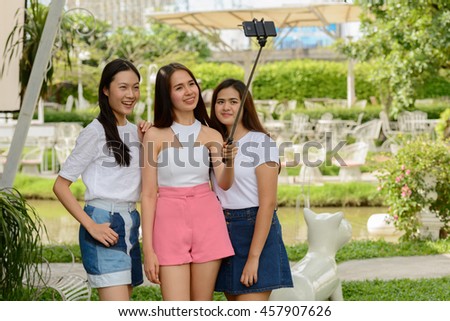 Asian teenagers friends taking picture outdoors