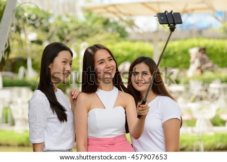Asian teenagers friends taking picture outdoors