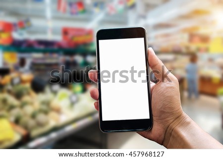 man hand hold and touch screen smart phone, tablet,cellphone over blurred shopping center or super market background.shopping 