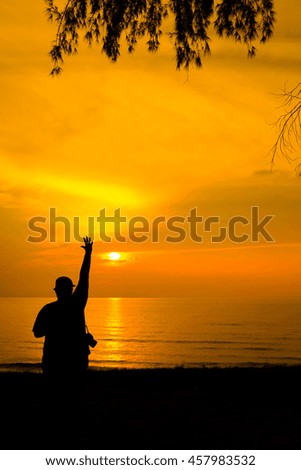A silhouette of man with the gesture of hand with the background of orange sunset. stock photo . copy space