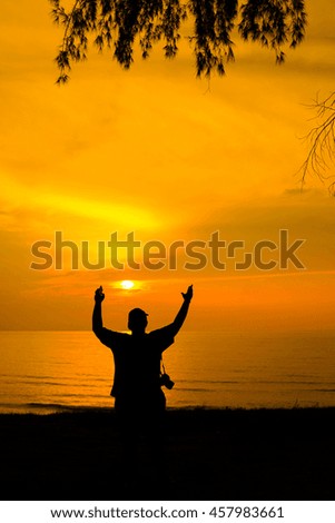 A silhouette of man with the gesture of hand with the background of orange sunset. stock photo . copy space