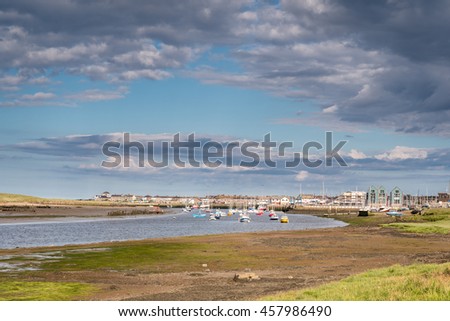 River Coquet flows passed Amble / Amble Harbour,  where the River Coquet meets the sea Royalty-Free Stock Photo #457986490