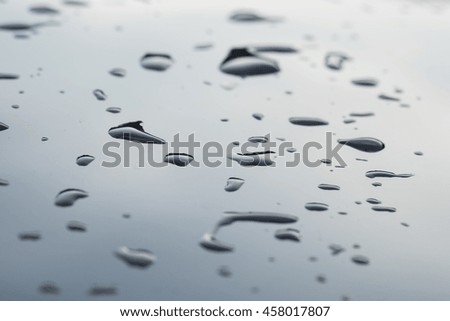 Water drops on the surface of black car