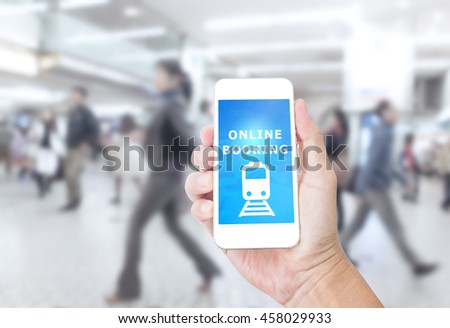 Hand holding smartphone with Online Booking on blurred image of business people background