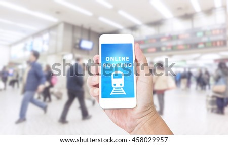 Hand holding smartphone with Online Booking on blurred image of business people background