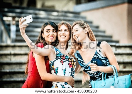 Three fashionable young women taking selfie on stairway, Cagliari, Sardinia, Italy