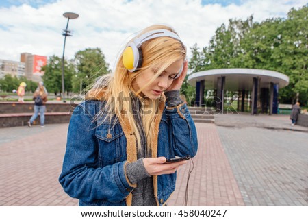 Girl listening to music streaming with headphones. Close up portrait.