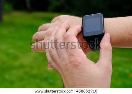 Smart watch with blank screen outdoors on green background