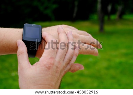 Smart watch with blank screen outdoors on green background