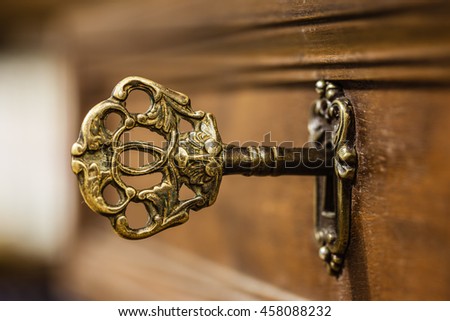 macro shot of an antique and weathered vintage key in his keyhole Royalty-Free Stock Photo #458088232