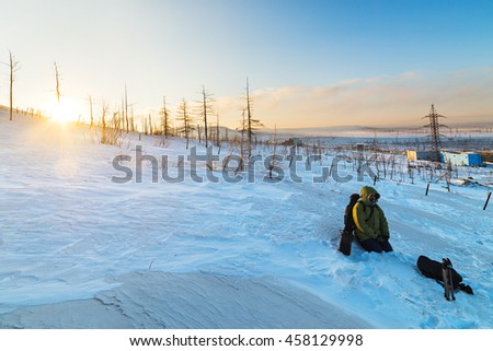 Photographer rests on the mountainside. Polar tundra winter.