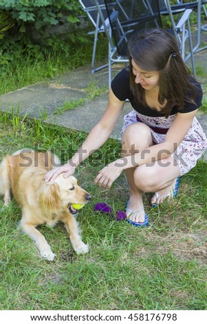 Young woman playing with golden retriever outdoors