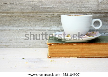 Full light composition with cup of fresh tasty coffee, vintage book with yellow shabby cover and paper and. Concept for beautiful romantic morning theme with retro decor elements