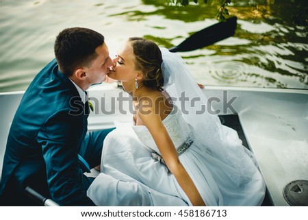 wonderful young  couple kissing each other  in a boat Royalty-Free Stock Photo #458186713
