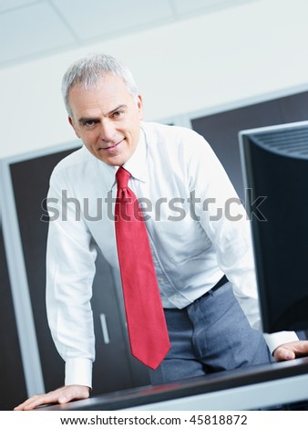 portrait of mature business man leaning on desk, looking at camera. Copy space