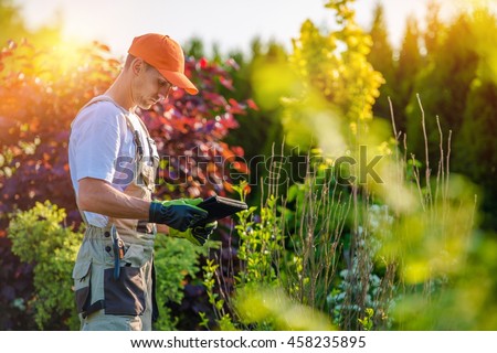 Garden Design with Tablet Device. Professional Gardener with His Tablet Computer. Royalty-Free Stock Photo #458235895
