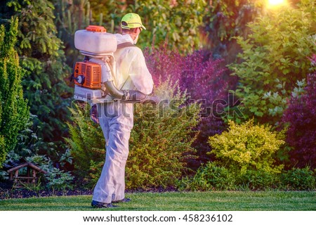 Pest Control Garden Spraying by Professional Gardener Who Wearing Safety Wearing. Royalty-Free Stock Photo #458236102
