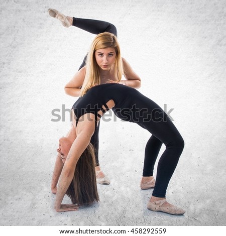 Two girls dancing ballet over textured background