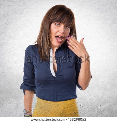 Pretty woman doing surprise gesture over textured background