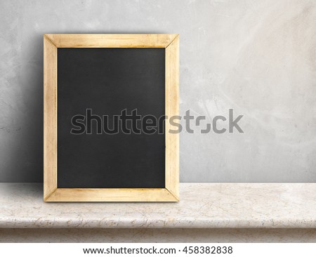 Blank blackboard on beige marble table at grey concrete wall,Template mock up for adding your design and leave space beside frame for adding more text..