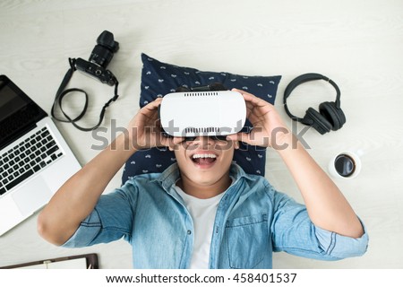 Top view of Man wearing virtual reality goggles Royalty-Free Stock Photo #458401537