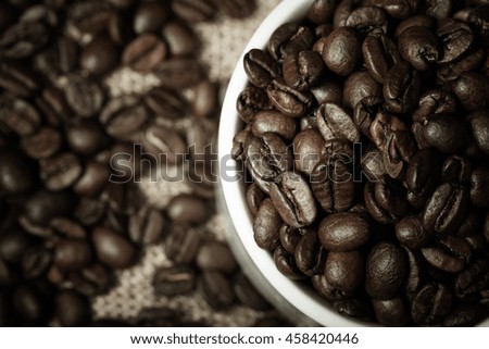 Coffee beans and coffee in cup on burlap. Selective focus. Toned.