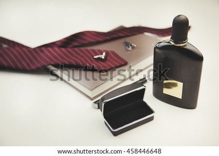 Business accessories on desktop: notebook, diary, fountain pen, cufflinks and perfume