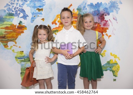 Three school children with a backpack on the background of the world map. Training, education, students, children