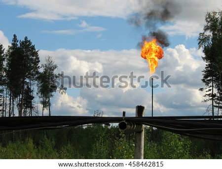 Picture of burning oil gas flare against blue sky