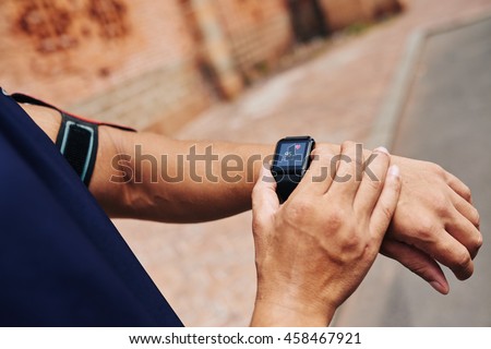 Cloe-up image of sportsman checking his pulse on smart watch Royalty-Free Stock Photo #458467921