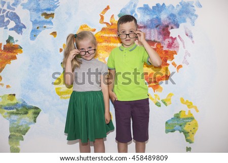 A small pair of students with glasses on the background of the world map