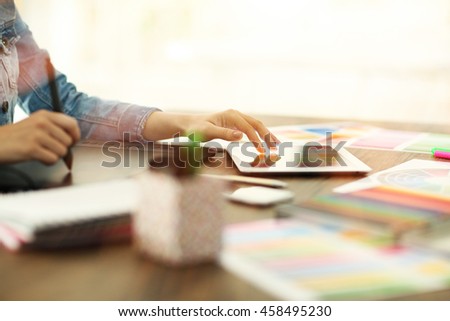 Designer workplace. Woman using tablet