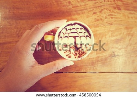 Cappuccino coffee with pattern umbrella of chocolate sauce in vintage color
