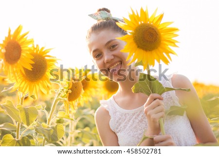 Happy girl having fun in spring field against blue sky background. Freedom concept