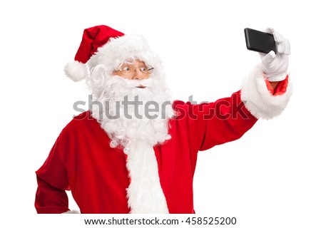Studio shot of Santa Claus taking a selfie with a cell phone isolated on white background