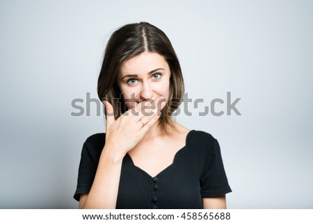 beautiful girl embarrassed, studio photo isolated on a gray background